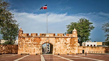 A historic stucture lines the road with a flag flying above.