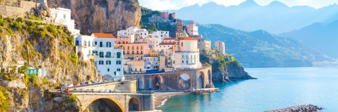 A city on the side of a mountain overlooking the sea.