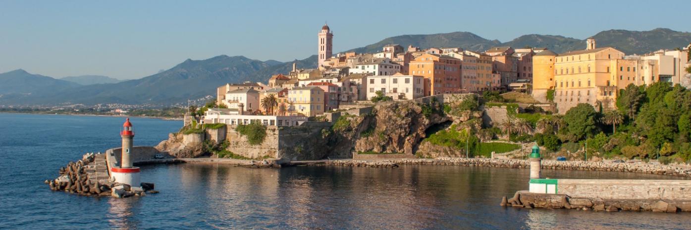 A city on the side of a mountain overlooking the sea.