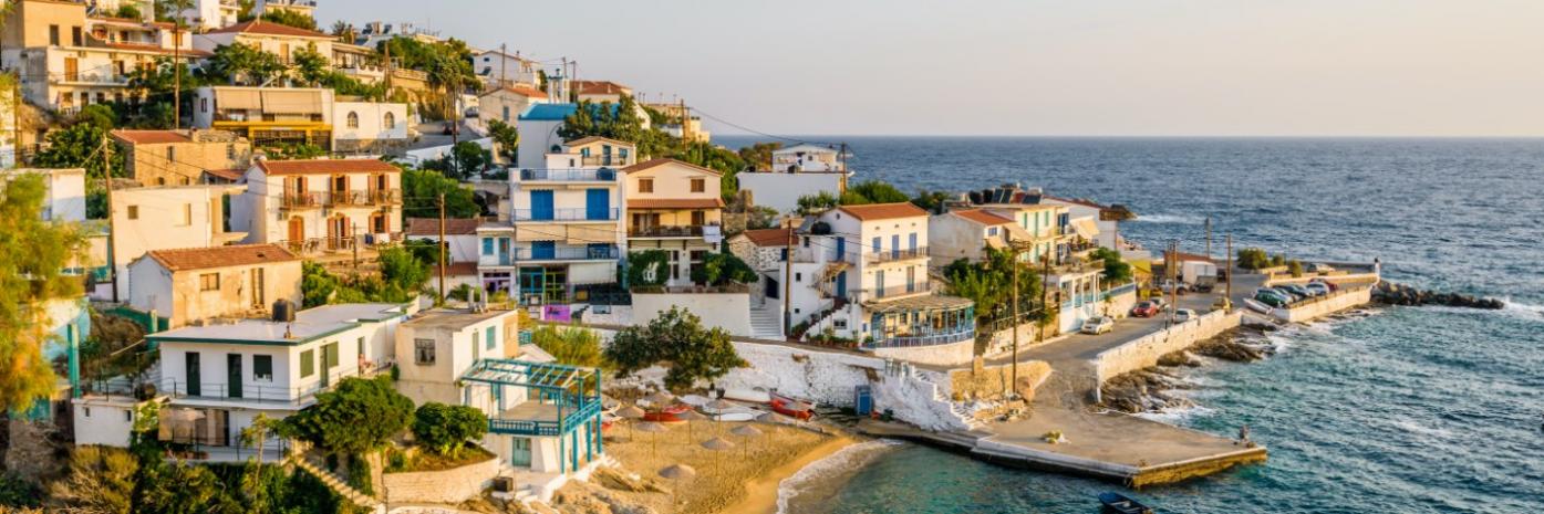Blue water washing up to a seaside town at sunset.