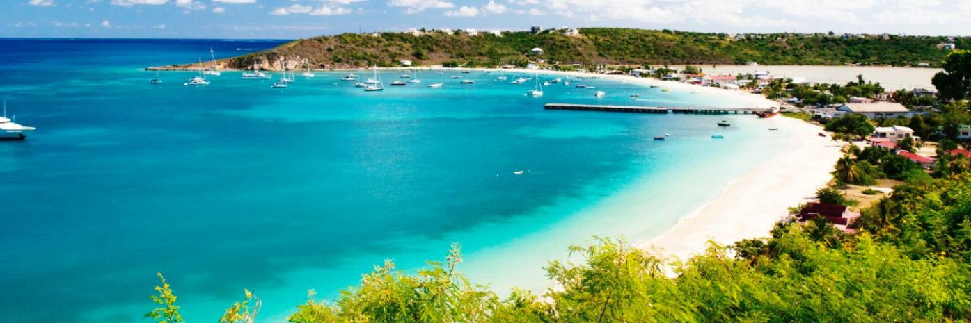 Bright blue water washes up on a white sand beach.