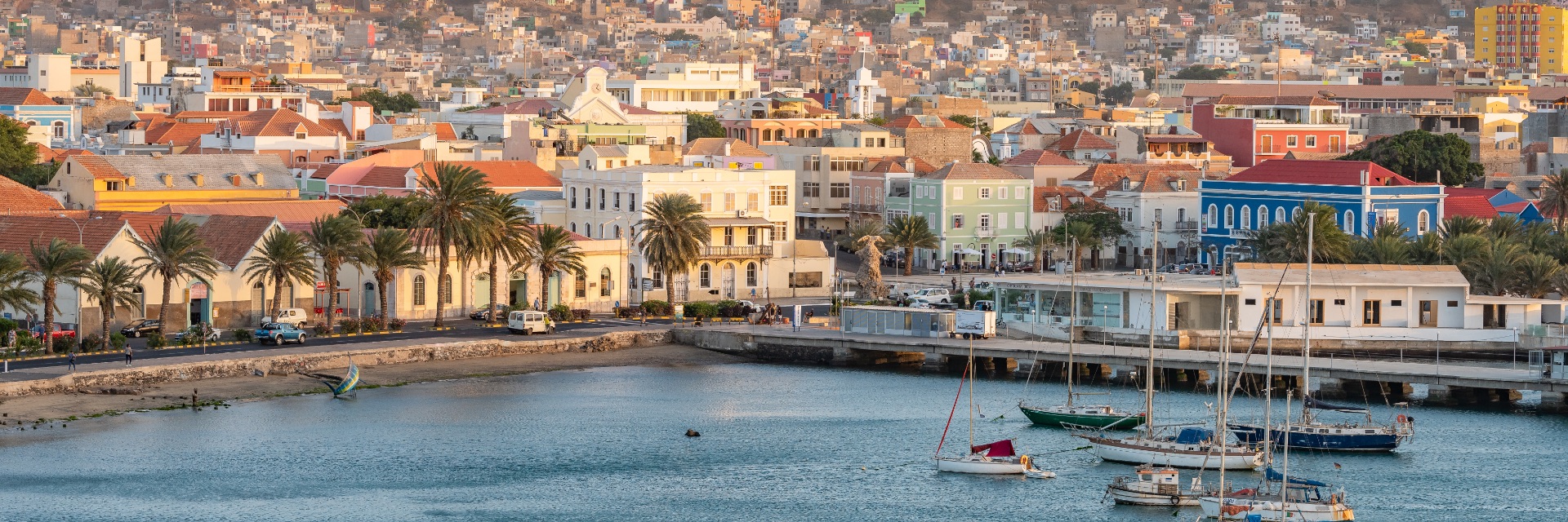A view from the water of a port town as sun sets.