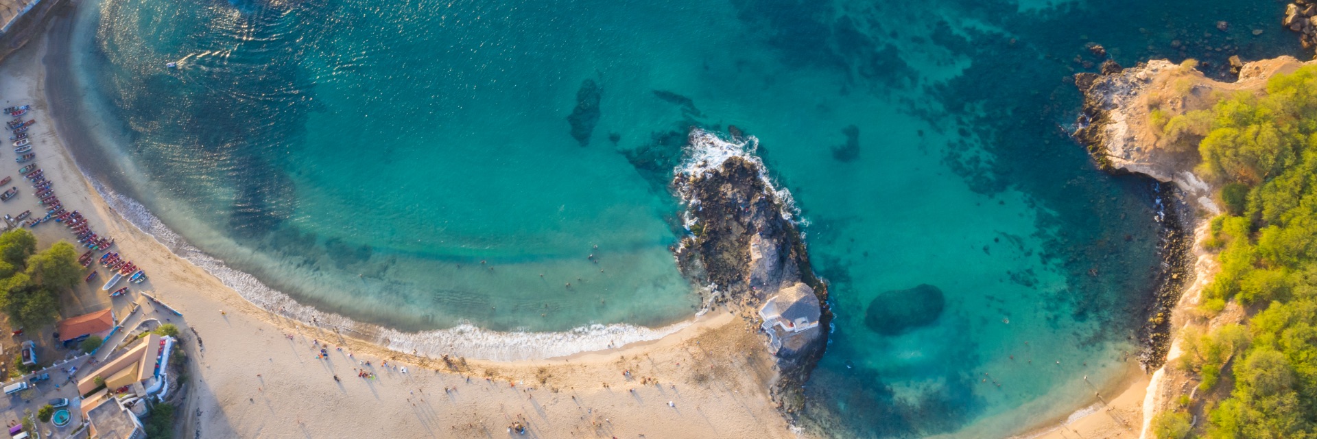 An aerial view of blue green water washing onto the white sand beaches.