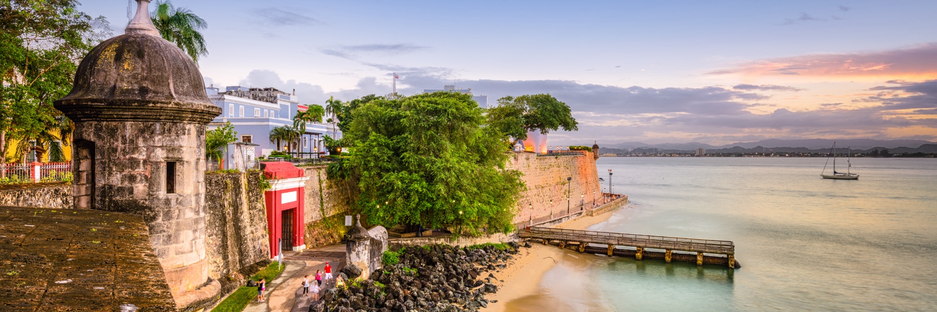The view of the coast from Old San Juan, featuring the stone wall and turrets of the ancient El Morro fortress.