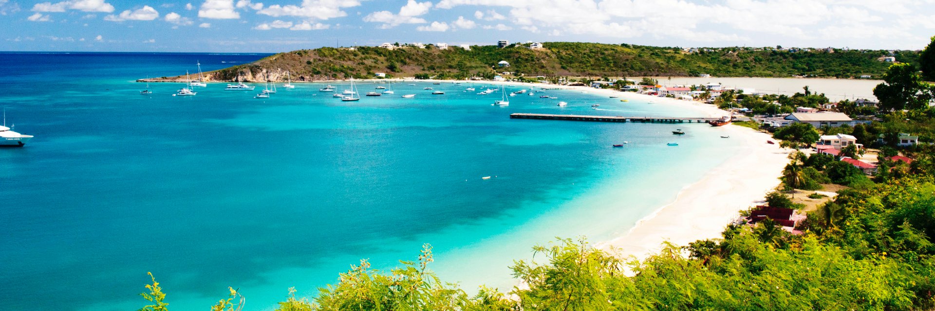 Bright blue water washes up on a white sand beach.