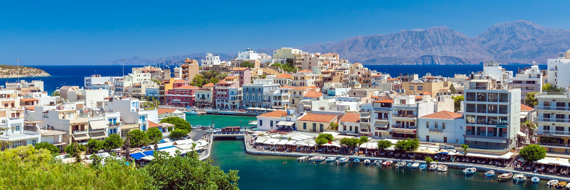 Lightly colored houses line the bright blue water's edge.