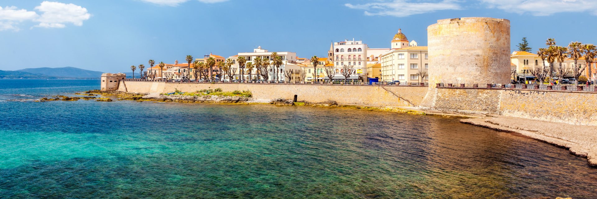 Bright blue water in front of a walled city.