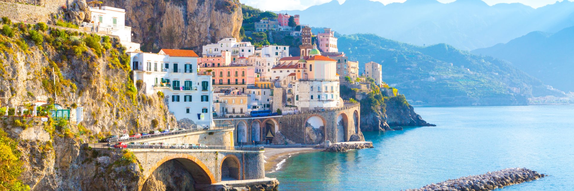 A town perched on the side of a cliff overlooking the ocean.