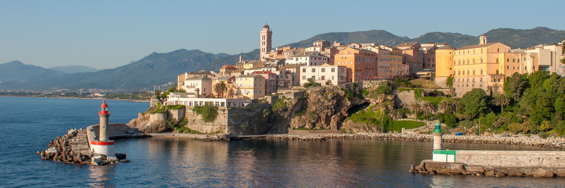 A city on the side of a mountain overlooking the sea.
