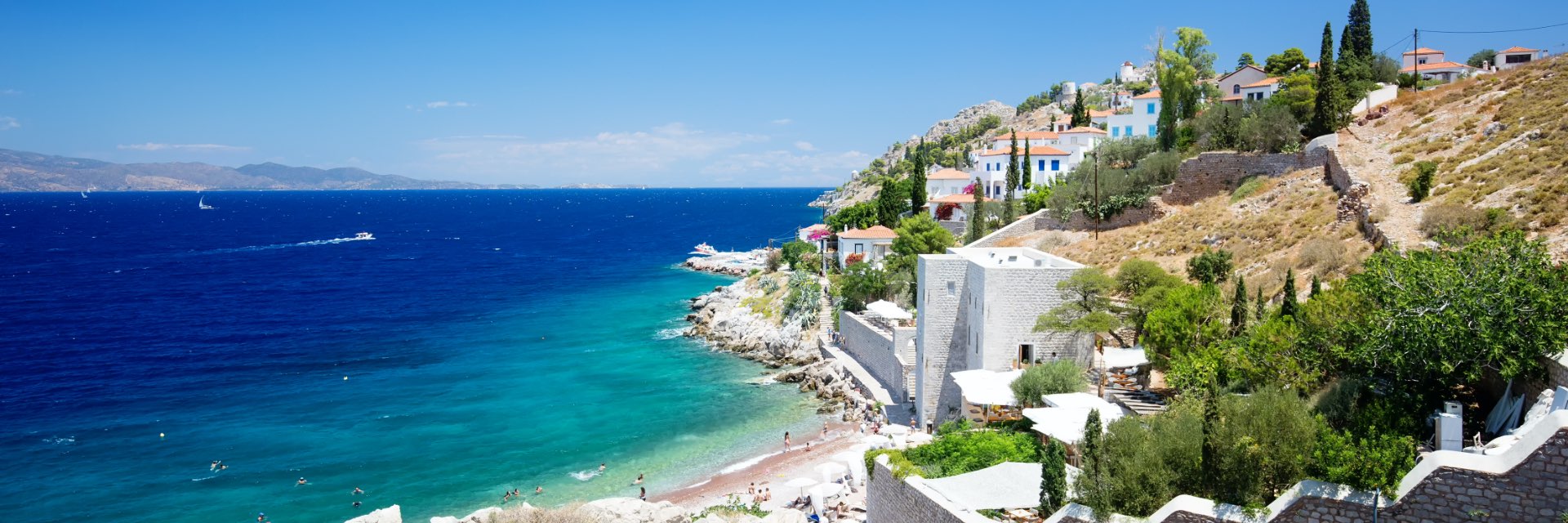 Vibrant blue water washes ashore in front of a white town.