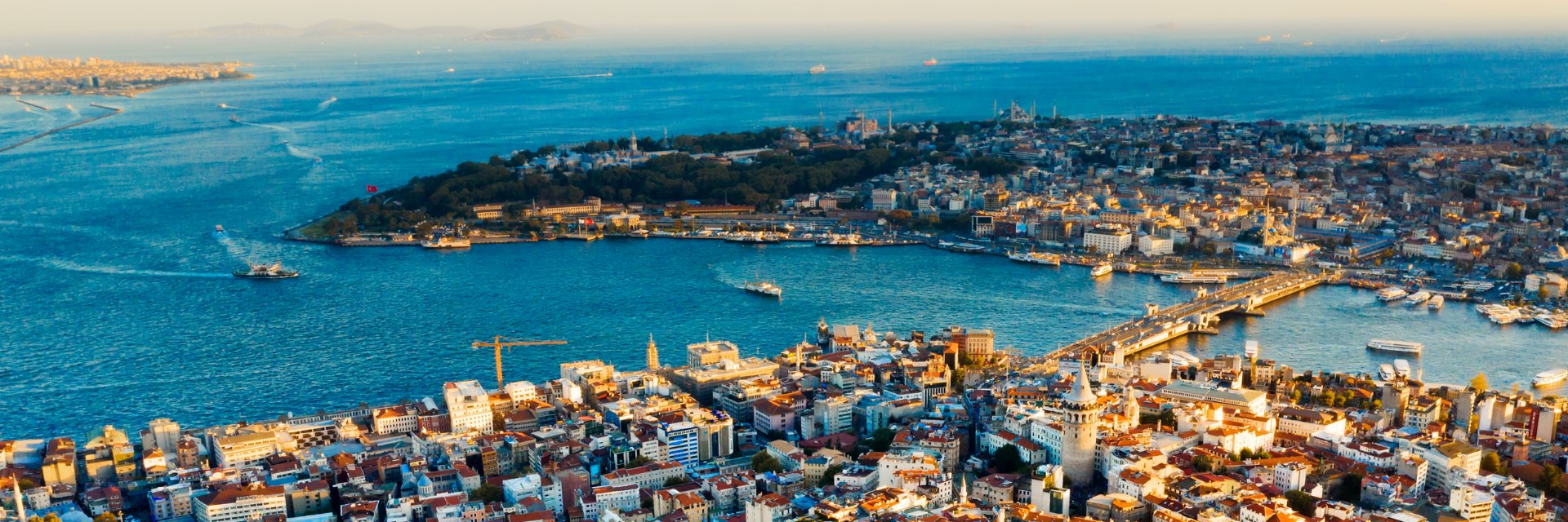 A sprawling city surrounded by water, connected by a bridge.