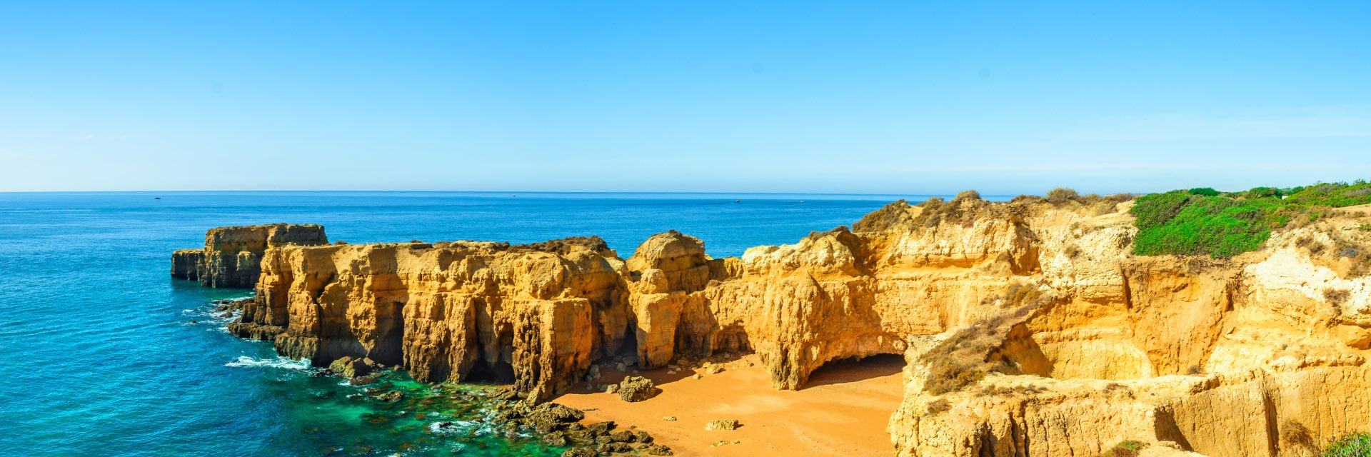 Panoramic view of Portugal beach among rocks and cliffs in a sunny day.