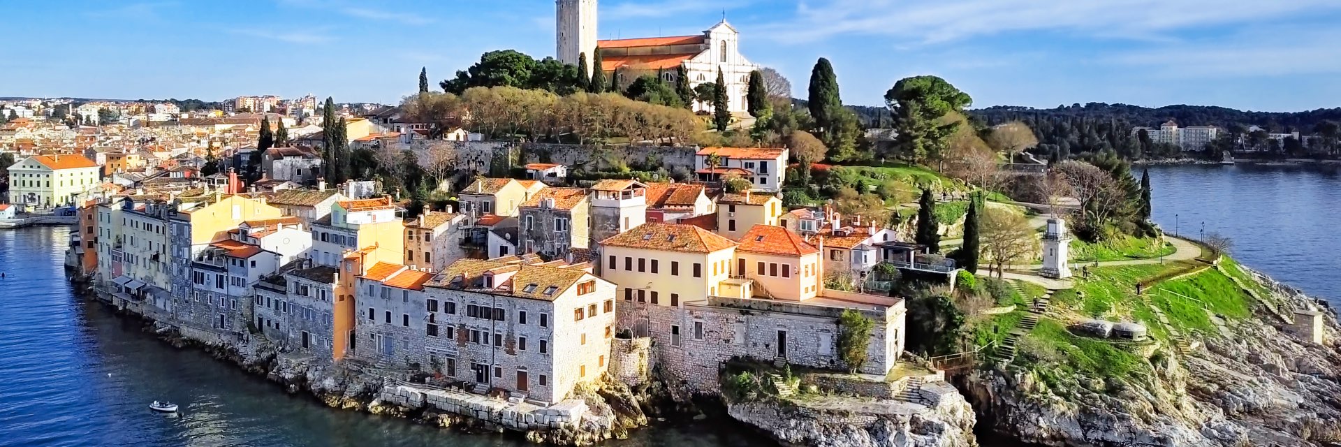 A town sits right on the rocky edge of the blue water.