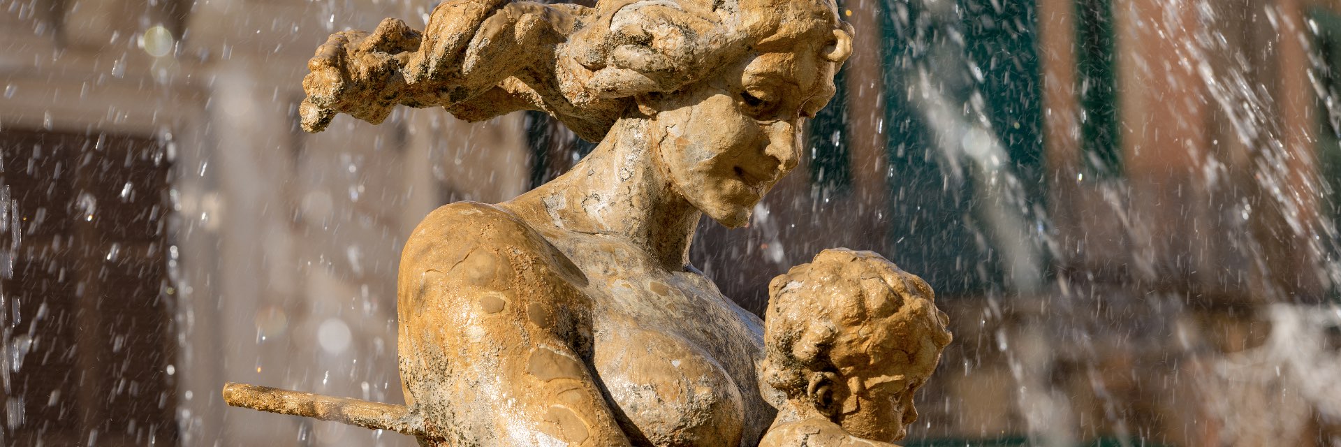 A statue of a woman and child in a fountain.