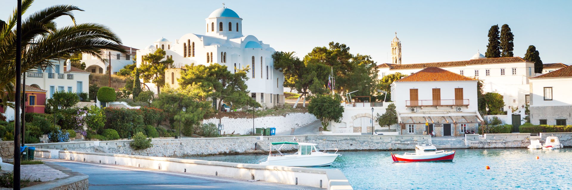 White buildings and palms along the water.