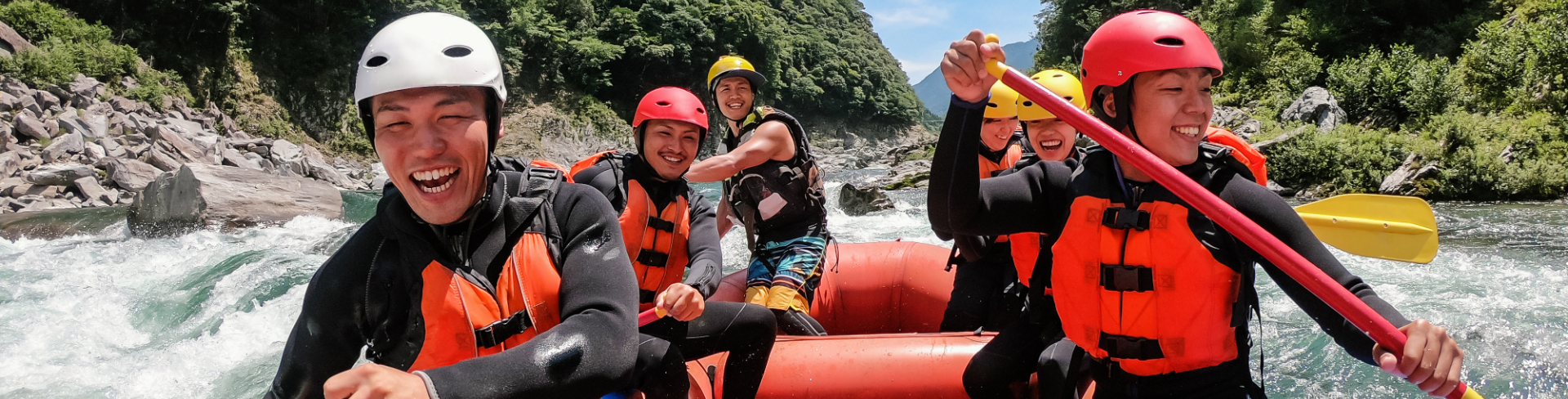 A group of people white water rafting on a river.