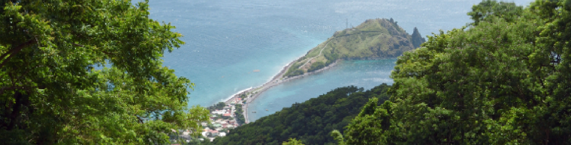 Landscape with green mountains and sea in the distance.