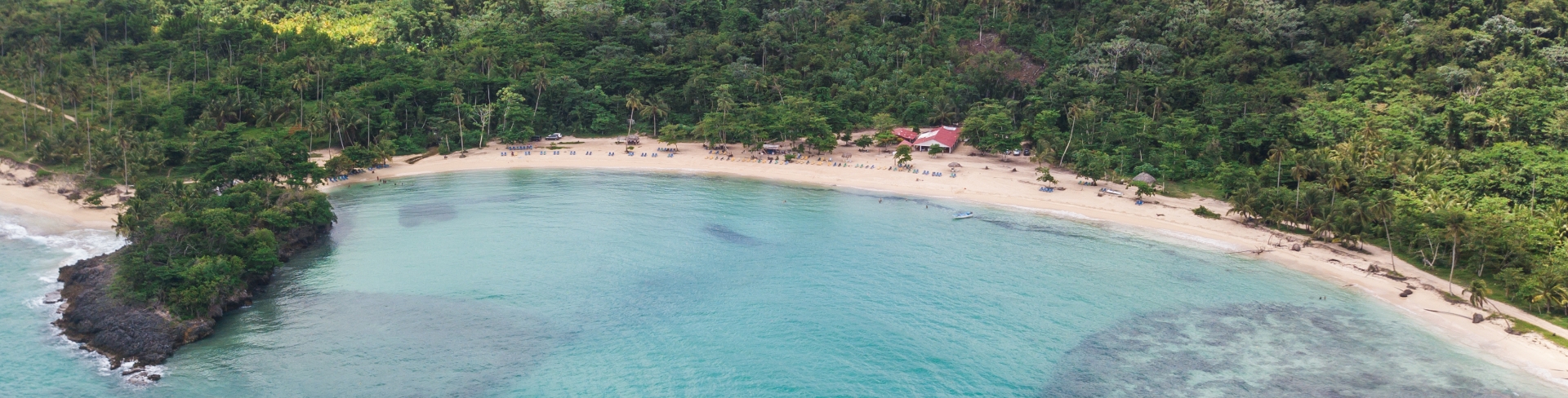 The view from above of a coastal area with its beach, nature, and crystal clear sea.