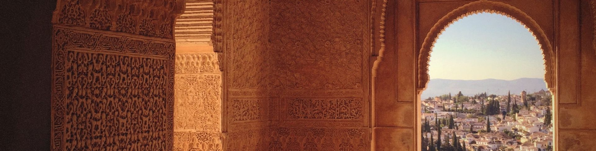 Looking through the ornamental arch of Alhambra at the city of Granada.