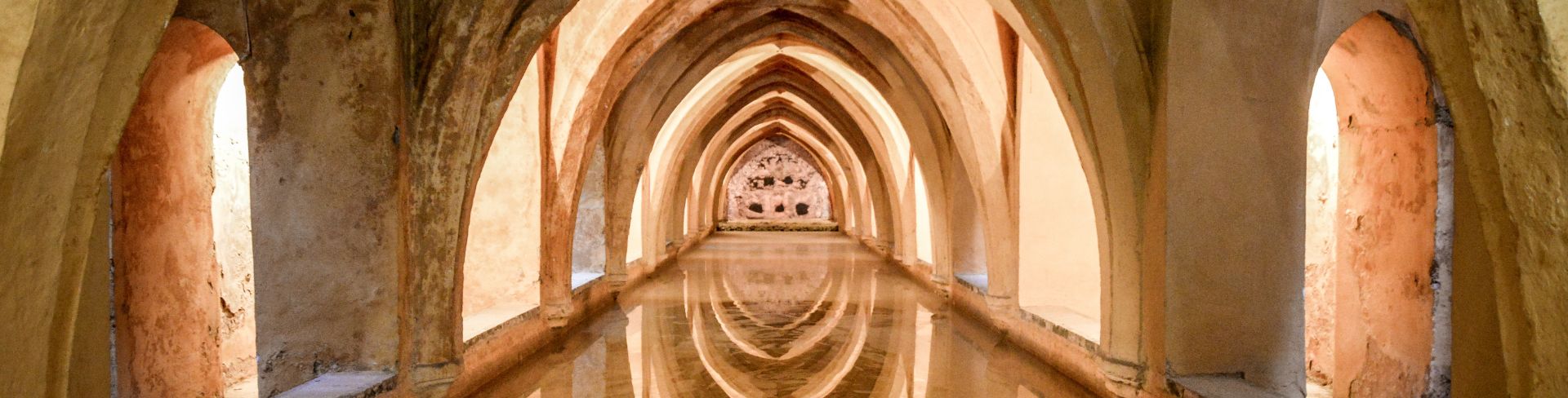 An ancient bath underneath a vaulted ceiling.