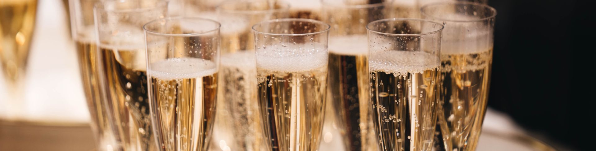 A tray of champagne flutes full of sparkling wine.