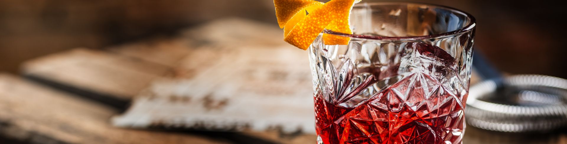A Negroni in an Old Fashioned glass garnished with orange peel.
