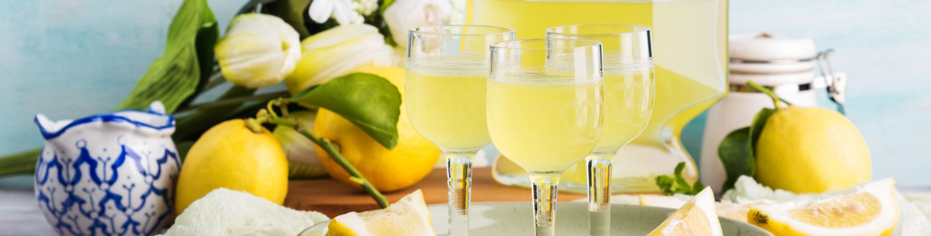 Homemade limoncello in a glass bottle and poured into small stemmed glasses.