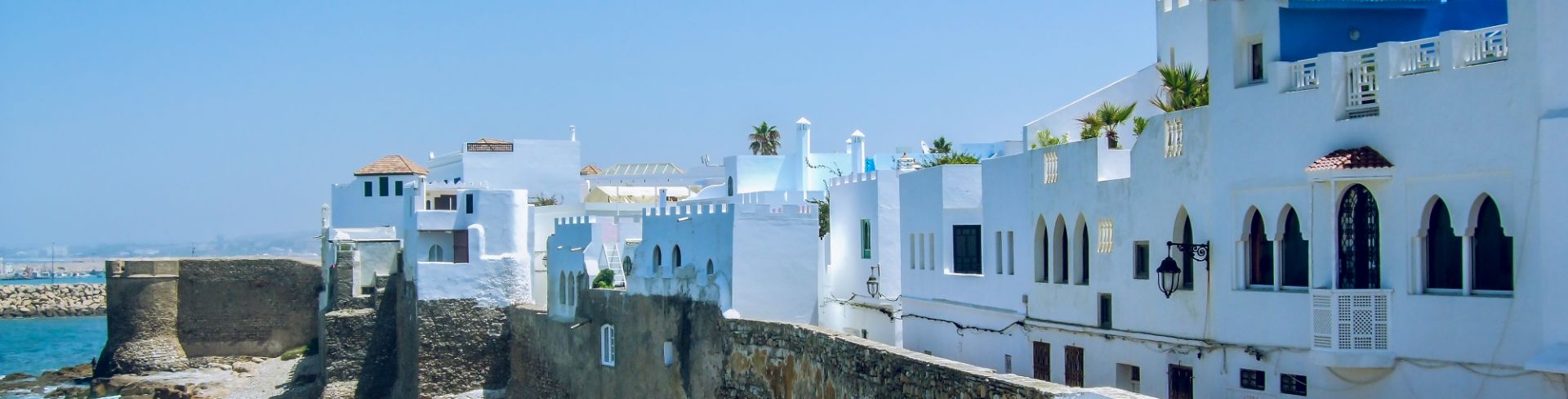 The old walled medina of Asliah with white buildings on the coast.