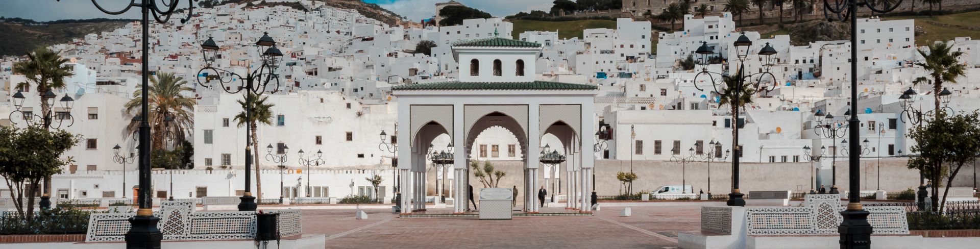 The ancient medina of Tetouan, a town of many buildings with white façades, at the foot of a mountain.