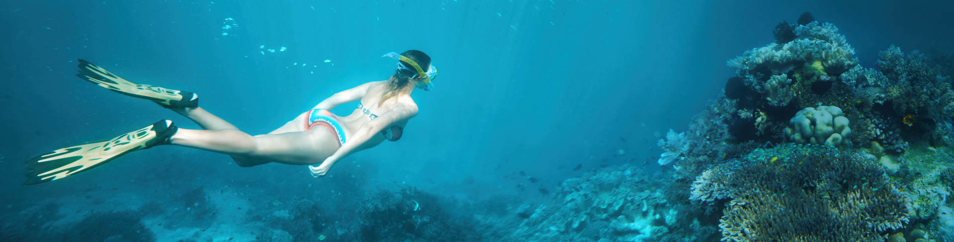 Girl swimming and snorkeling in azure water.