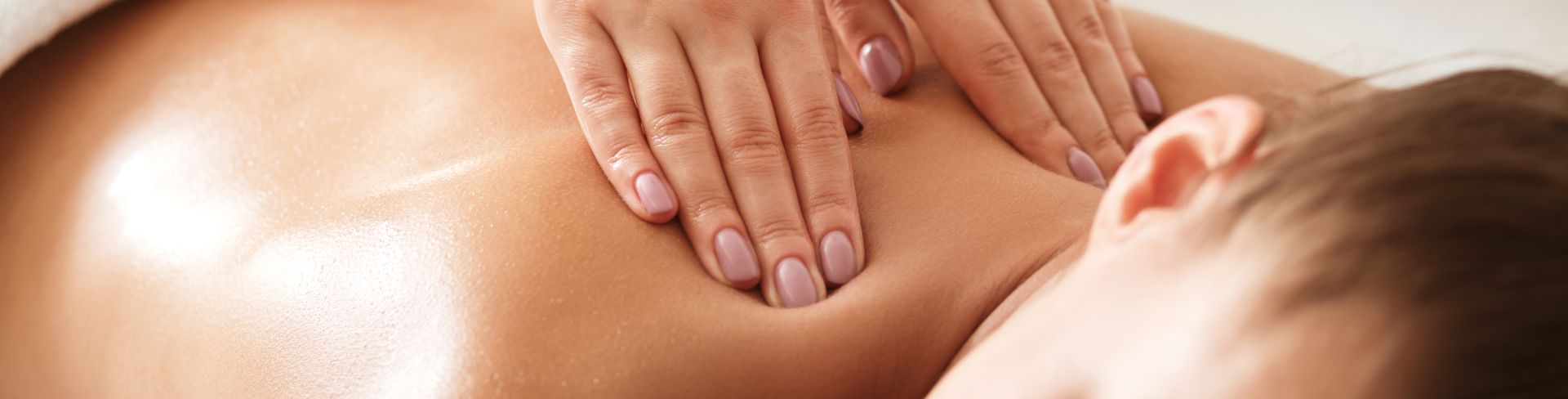 A masseuse gives a woman a back massage. 