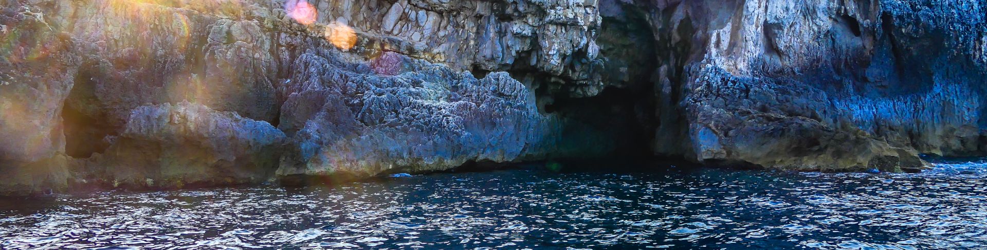 The view from the water of sea caves on a sunny day.