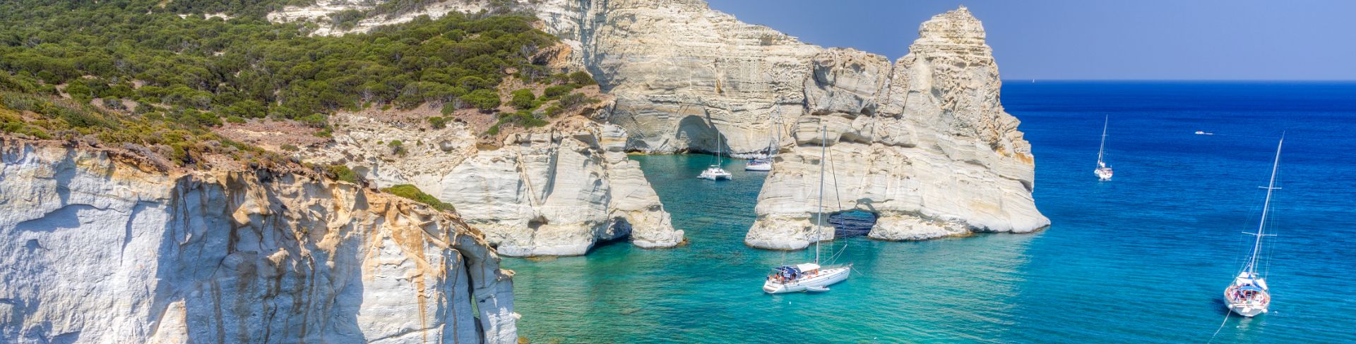 The rocky coast looks over blue green waters.