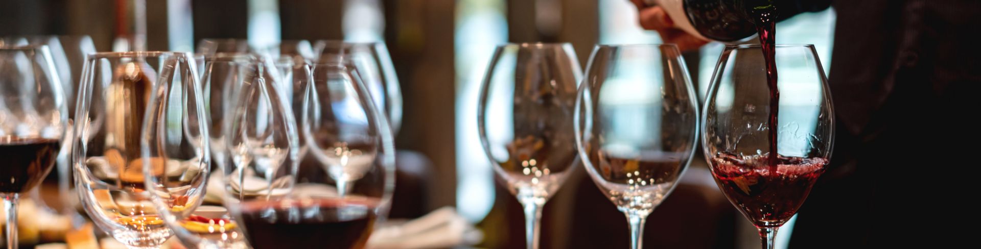 A spread of wine and hor d'oeuvres sits on a wood table. 