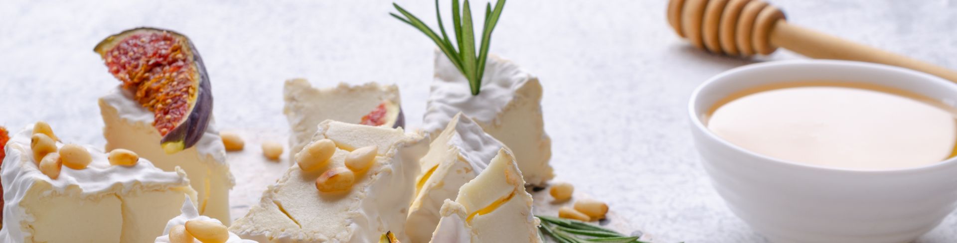 A plate filled with local cheeses sits next to a bowl of honey.