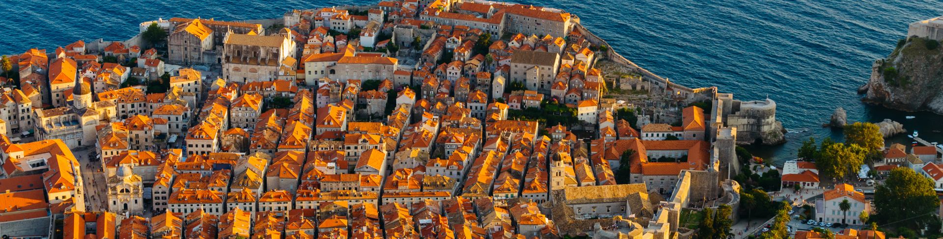 An aerial view of the famous orange roofs lit up by the evening sun.