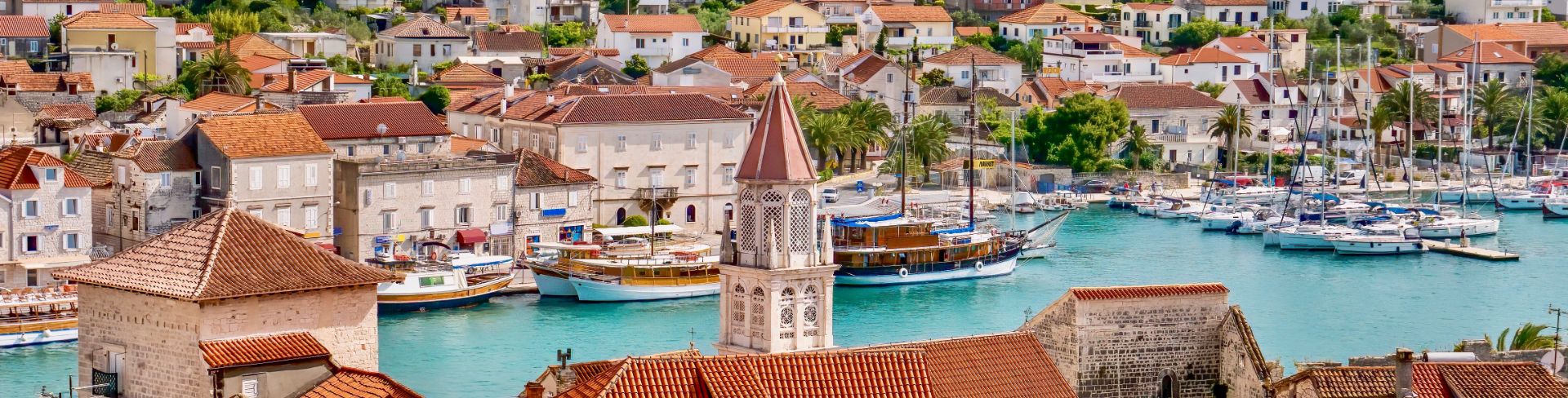 A picturesque view of the city filled with orange roofs and surrounding turquoise waters.