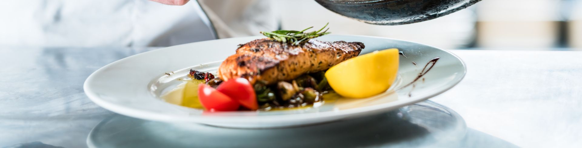 A chef prepares a plated dish.