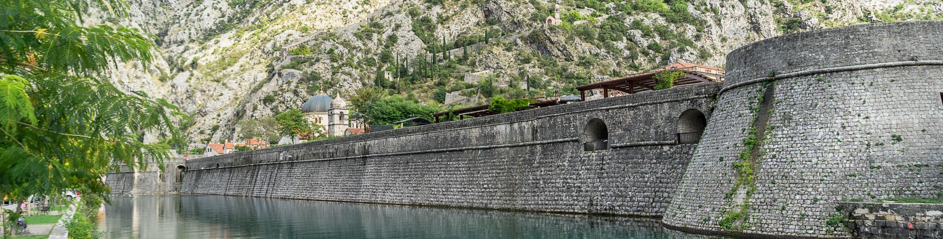 The ancient city wall of Kotor sits next to the water's edge. 
