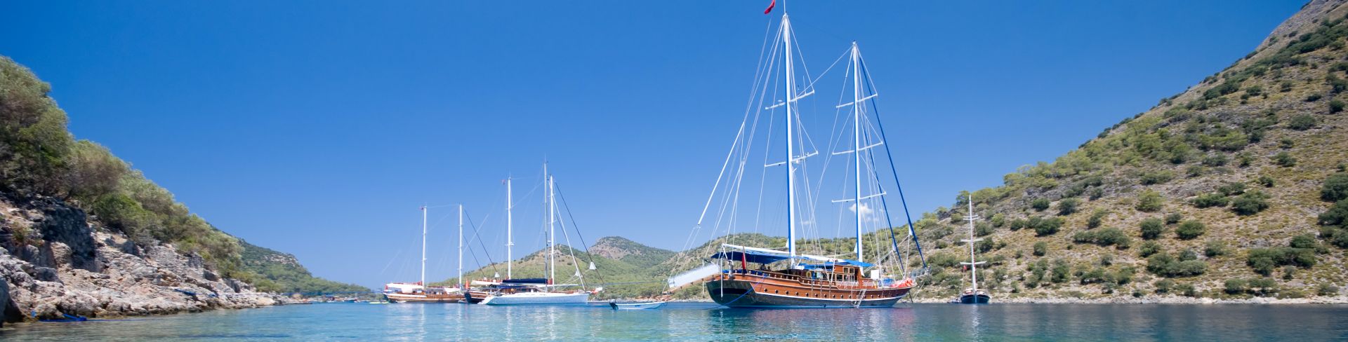 Sailboats sit in the turquoise waters of the Dilek Peninsula. 