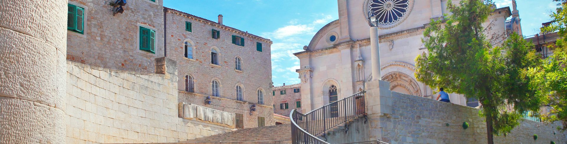 A church sits at the top of the paved steps under the blue sky.