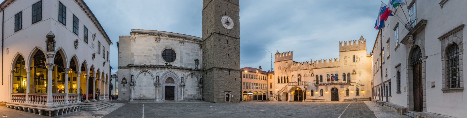 In the middle of the city square sits a clock tower. 