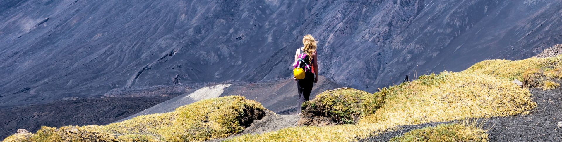 A woman on a hiking path on Mount Etna in Italy.