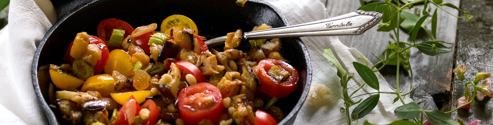 A skillet of caponata, a Sicilian dish of chopped fried aubergine and other vegetables.
