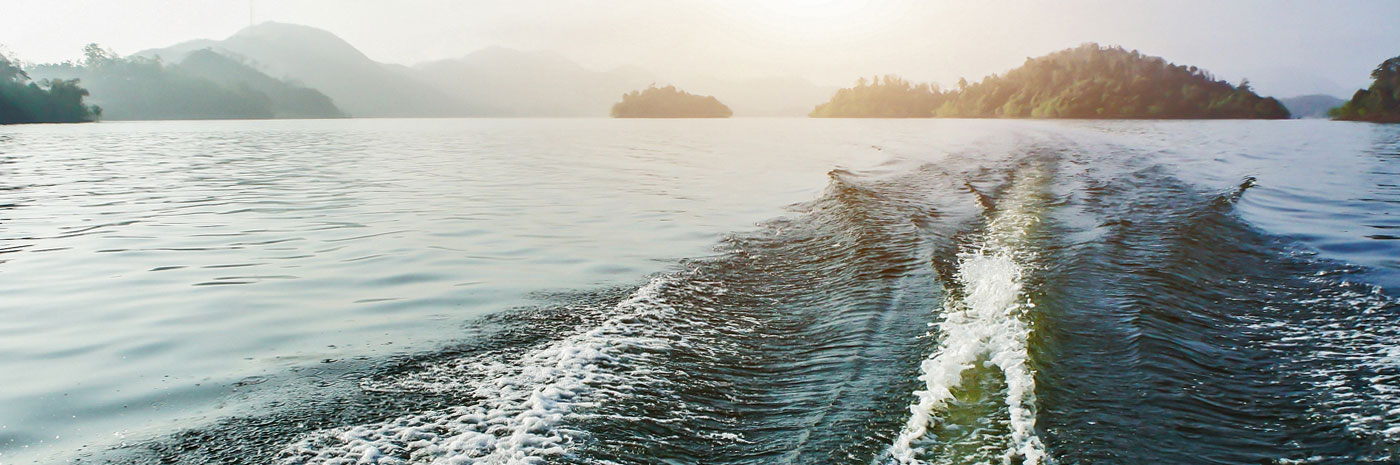 The wake of a ship with islands in the background.