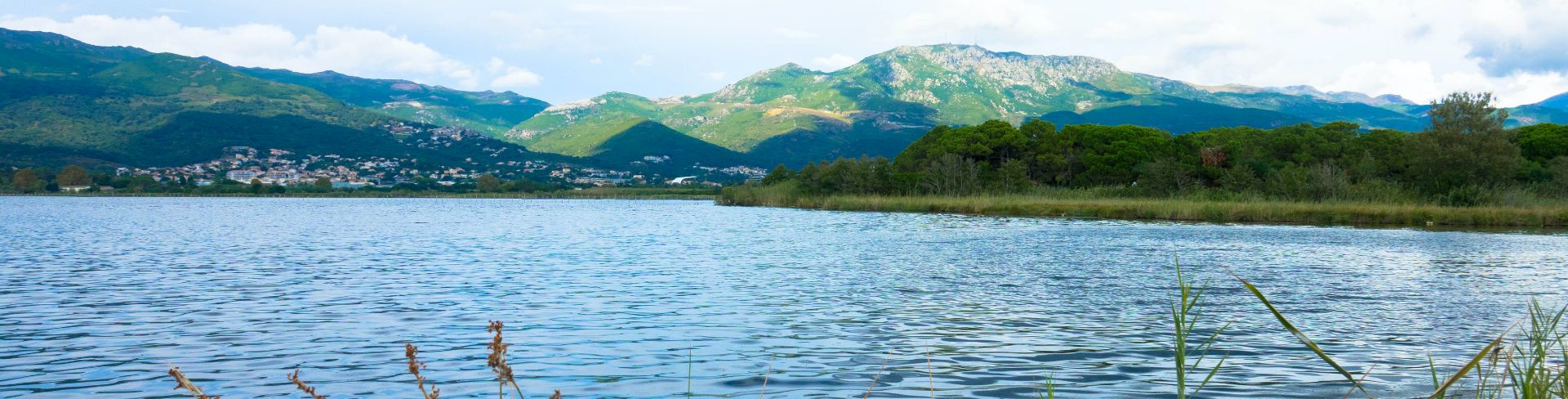 A panoramic view of L'Étang de Biguglia, a lagoon, with Corsica in the background.