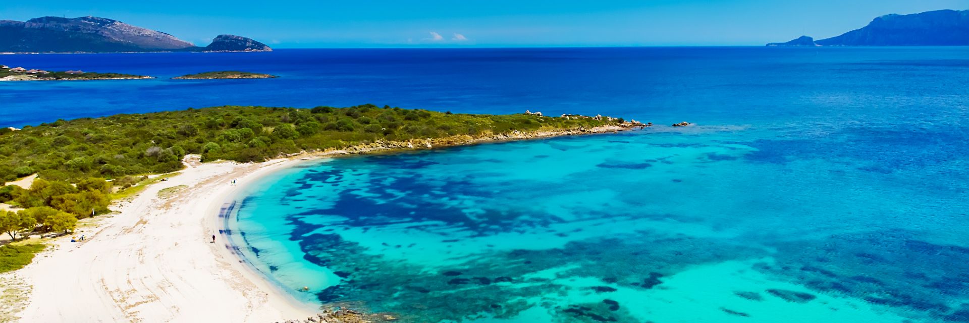 An aerial view of the bright blue waters off the white sand beaches of Olbia, Sardinia.