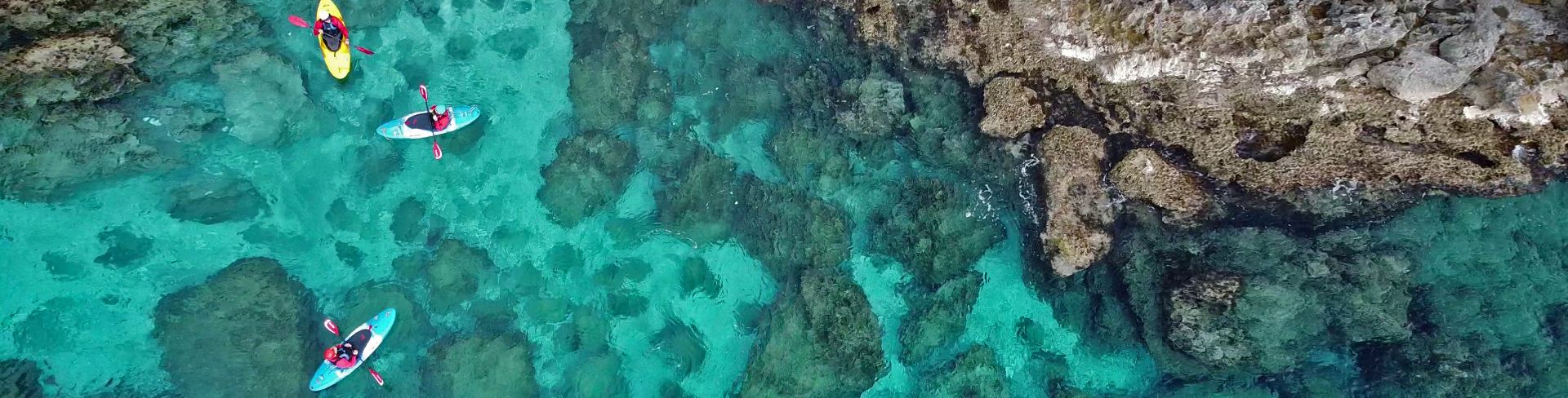 Four people Kayaking in the waters of Parga, Greece.