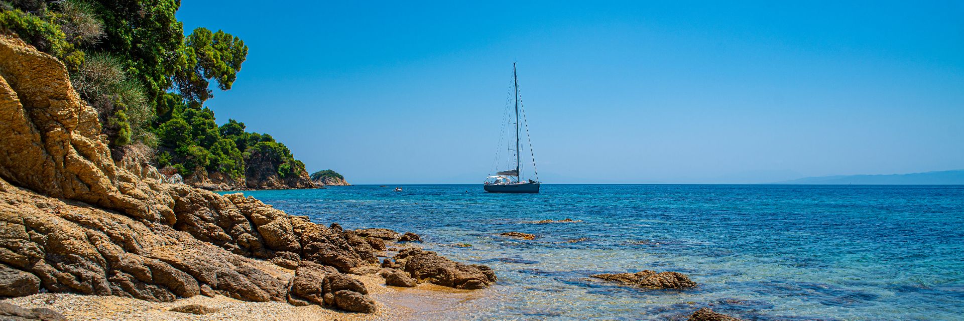 A golden sand beach on the coast of Skiathos, Greece.
