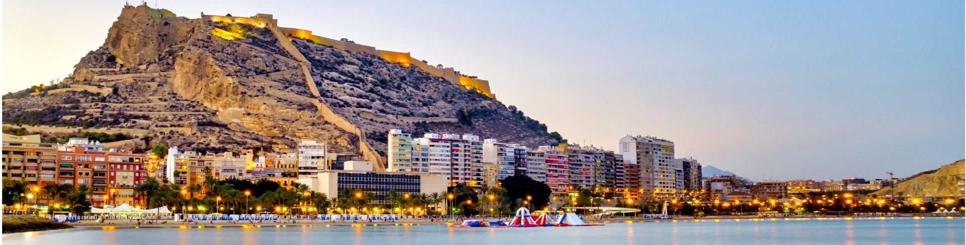 The view of Postiguet Beach at dusk from the water.